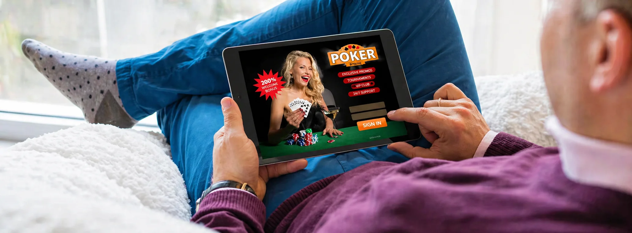 A man relaxes on a sofa, browsing a digital poker website on a tablet