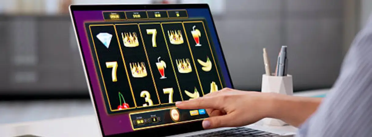 A person plays an online slot machine game on a laptop