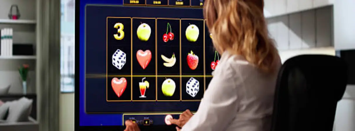 A person plays an online slot machine on a large monitor at home